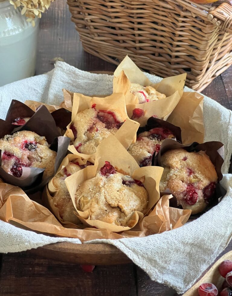Easy Cranberry Muffins sprinkled with sugar in a wood bowl lined with linen napkin
