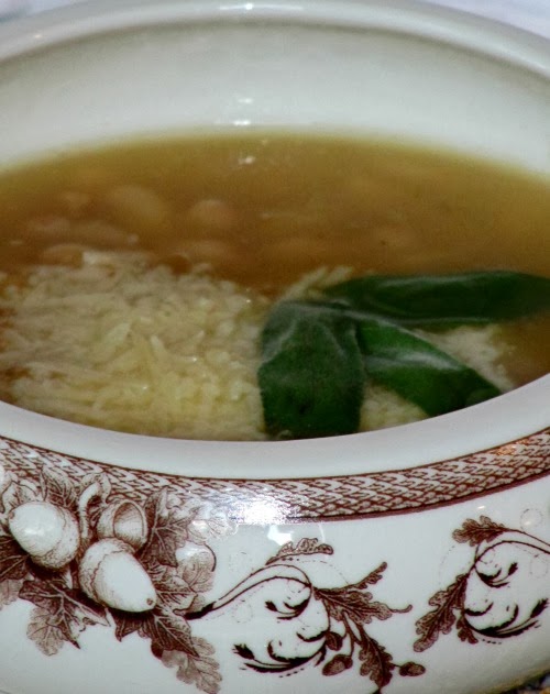 soup in a brown and white bowl.