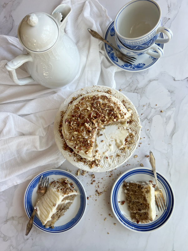 Hummingbird cupcakes and cake on blue and white plates with a white teapot.