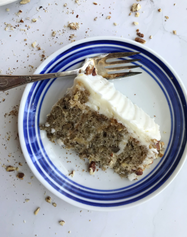 hummingbird cake sliced on a blue and white plate.