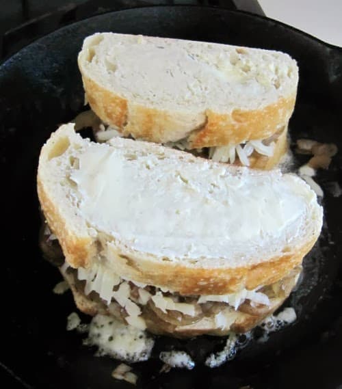 French onion sandwiches in a cast iron skillet.