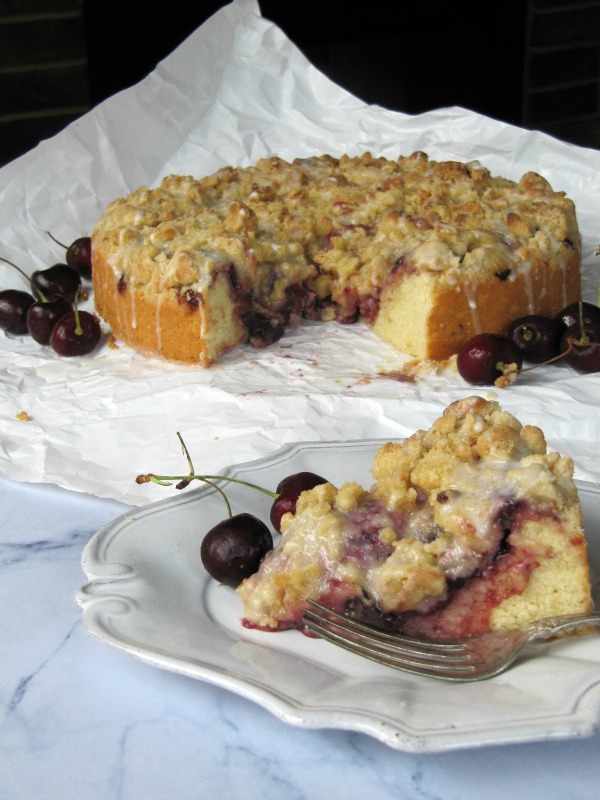 Cherry almond coffee cake sliced on a plate.