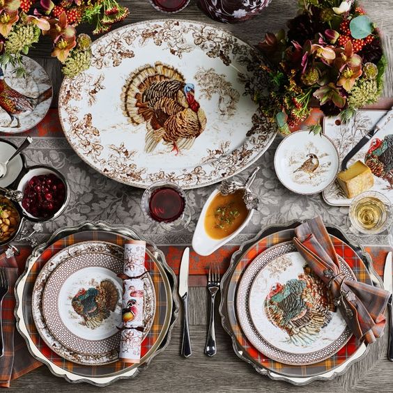 Thanksgiving table with brown and white transfer ware turkey platter and plates, plaid plates and traditional flowers