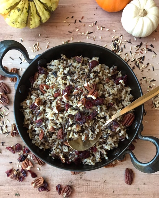 large round cast iron pan filled with wild rice with cranberries and pecans