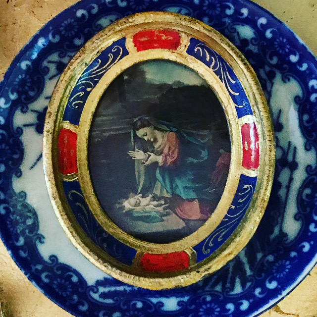 blue and white plate with a small oval picture frame with Mary and the baby Jesus