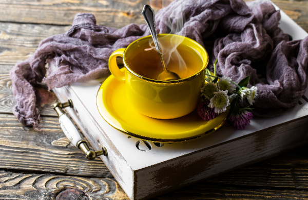 5 Easy Ways to Drink More Water, yellow cup and saucer of tea on a white box with a purple scarf