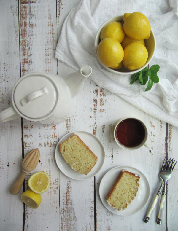 lemon loaf cake with lemon drizzle and a bowl of lemons