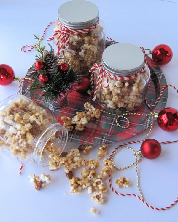The Best Easy Caramel-corn(no bake) in 3 glass jars sitting on a plaid tray.