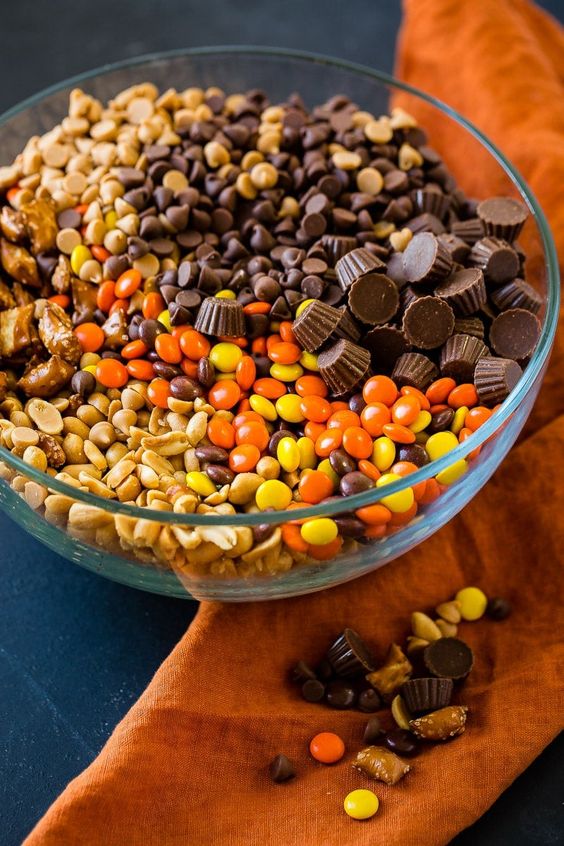 a bowl of peanut butter cups, Reeses pieces, peanuts to make a snack mix.