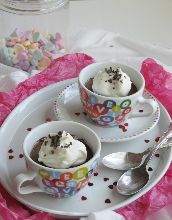 Vegan chocolate ganache mousse in 2 cups with hearts on a white tray.