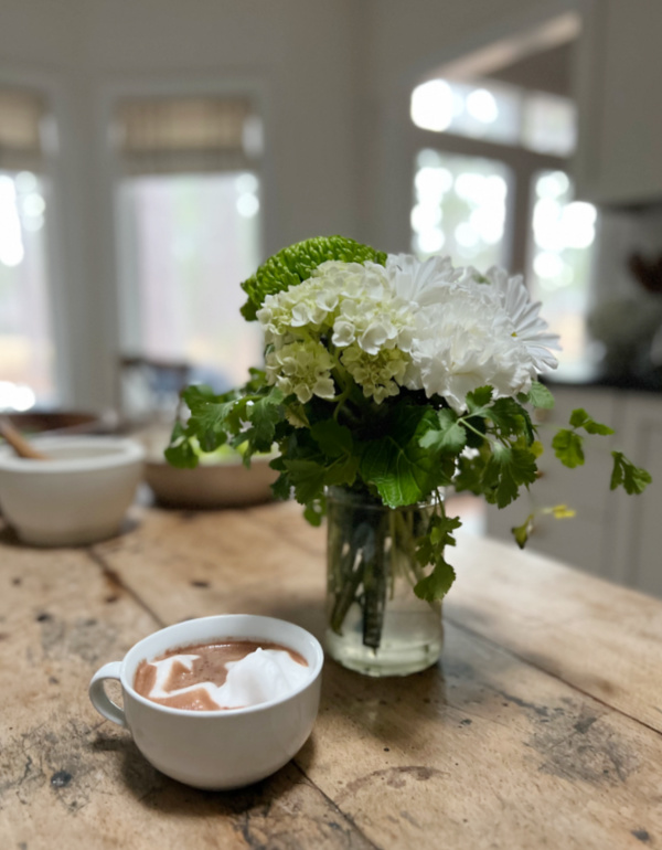 White flowers and herbs in a glass jar.