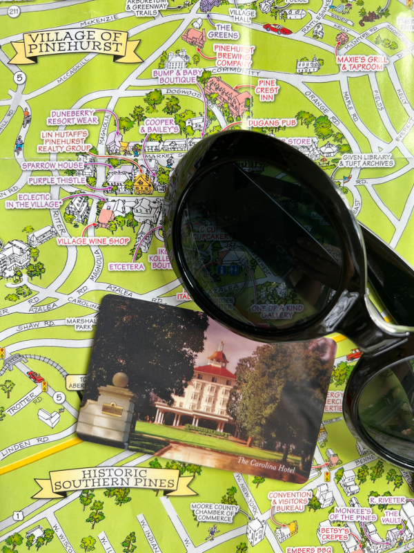 Map of Pinehurst with a key card for The Carolina Hotel and a pair of sun glasses. 