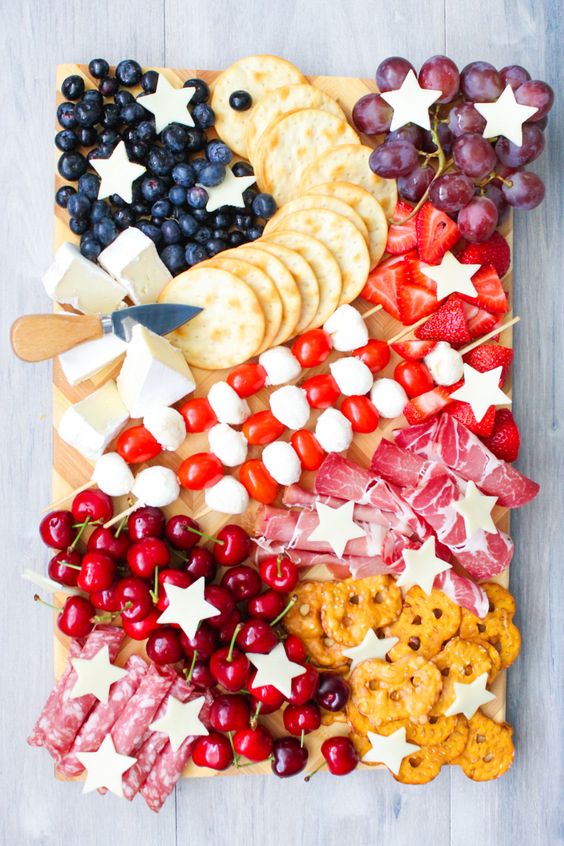 Patriotic cheese board with fruit and crackers.