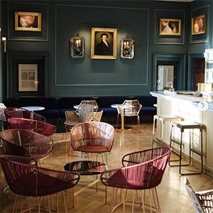 The Newt lounge bar with green walls and salmon velvet chairs.