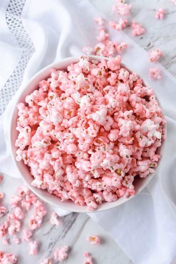 Pink popcorn in a white bowl. 