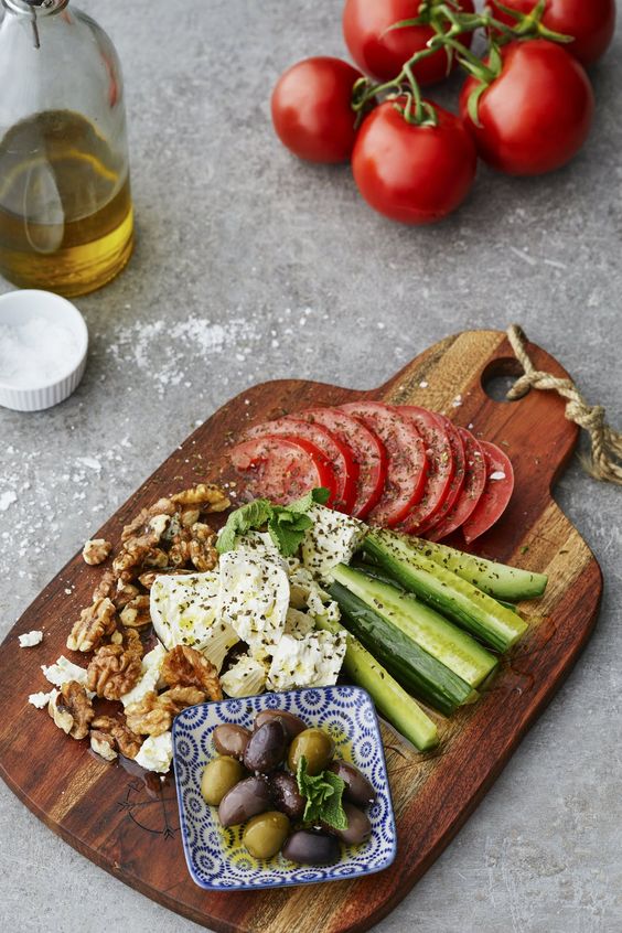 Mediterranean Vegetable and Cheese Board with tomatoes, nuts, cheese, cucumber.
