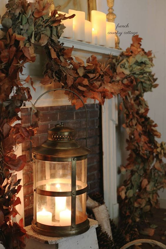 Fall mantle with a lantern and a swag of magnolia leaves
