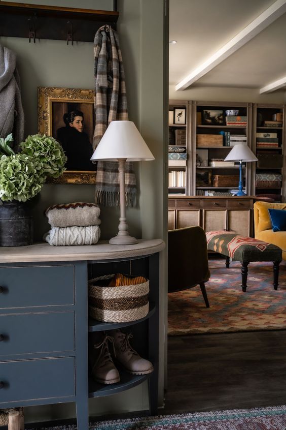 The foyer of an English cottage looking into a living room.