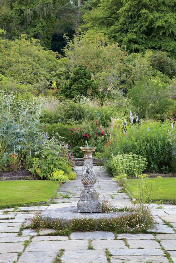 GRAVETYE MANOR gardens with a sundial in the middle.