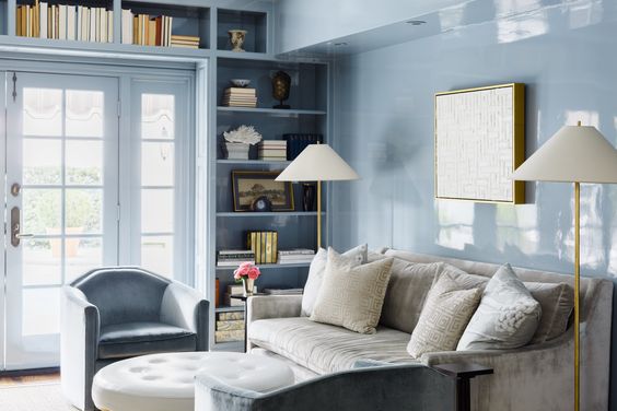 Paloma Contreras designed light blue lacquered wall study with a couch, chairs and bookcase. 