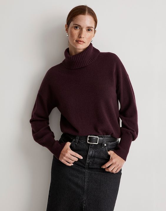 Woman wearing a wine colored turtleneck sweater. 