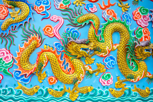 colorful yellow Chinese Dragons on a bright blue wall.