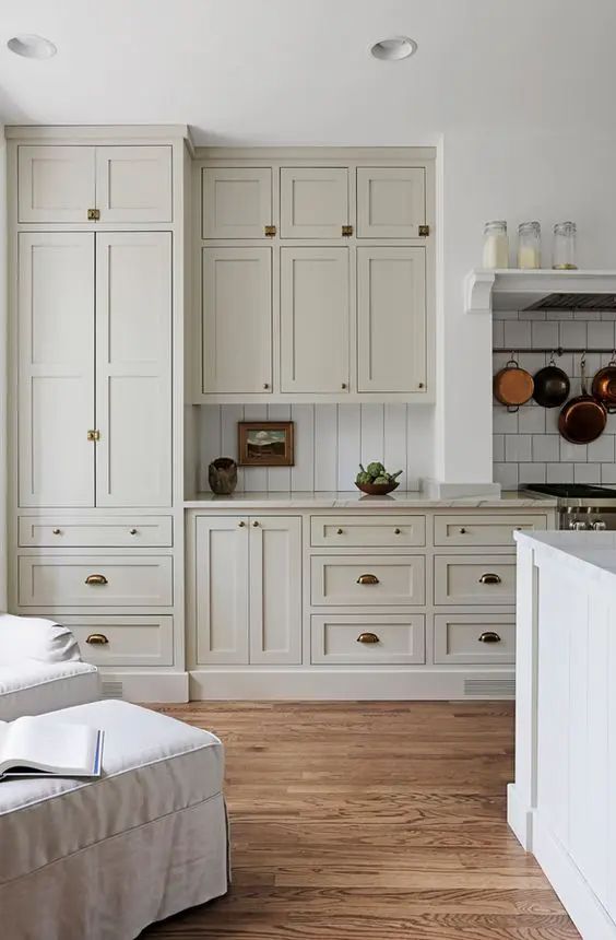 Off white kitchen with copper pots. 