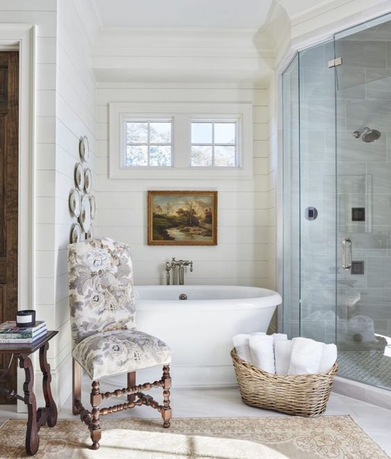 Maggie Griffin Design white bathroom with a free standing tub and an oil painting above it.