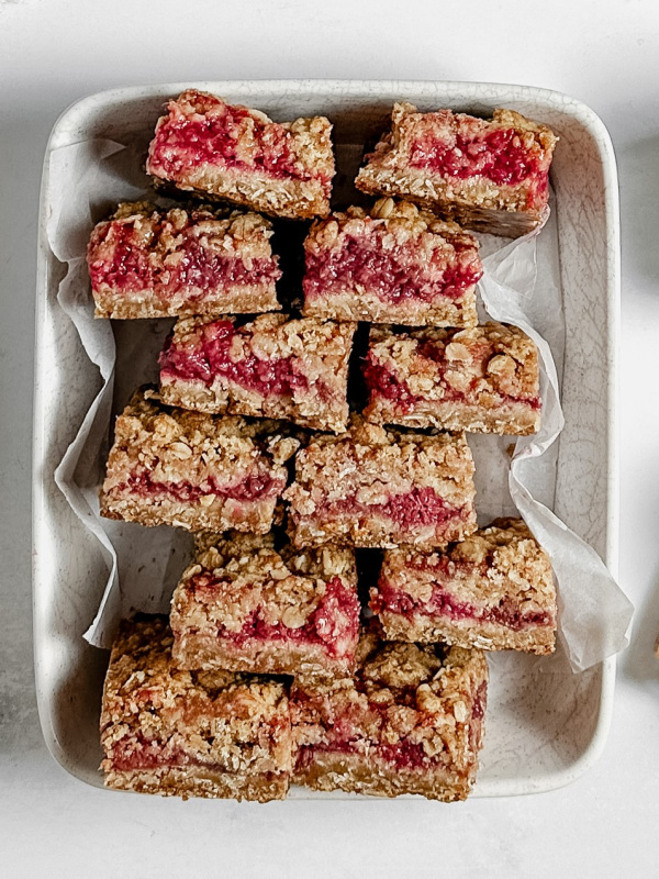 Raspberry oat bars in a white baking pan. 