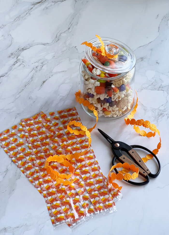 sweet fall snack mix in a glass jar with cellophane treat bags