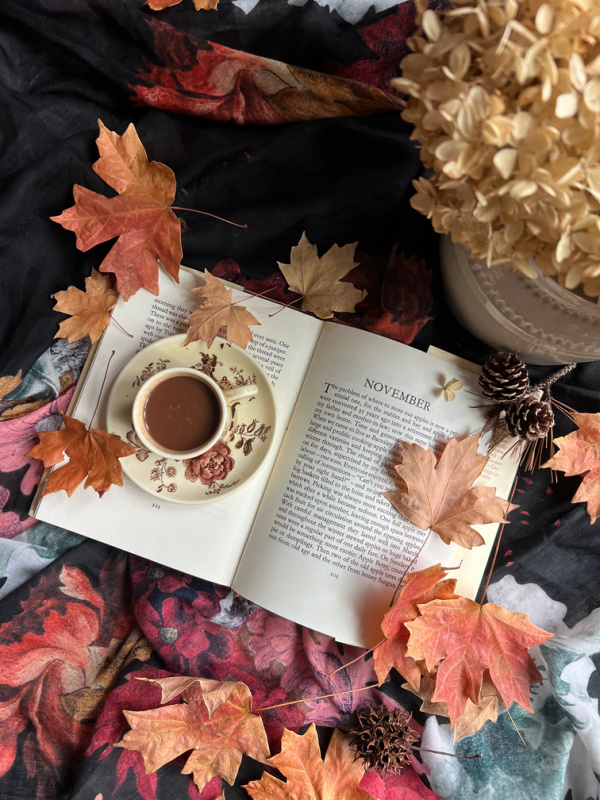 41-little-things-to-love-about-fall November flatlay with fall leaves, dried hydrangeas and a book opened to November.