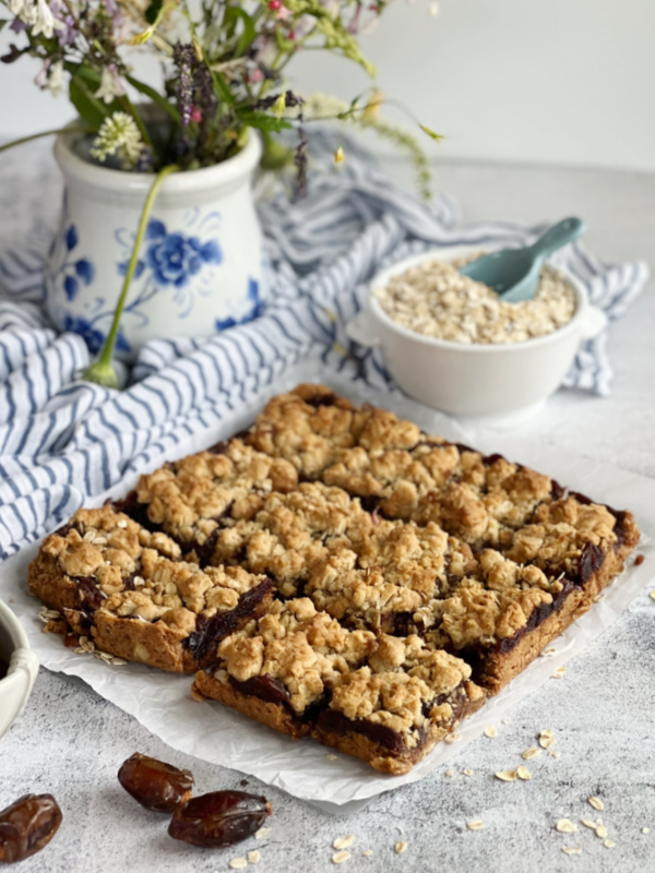 sliced date bars and a bowl of rolled oats.