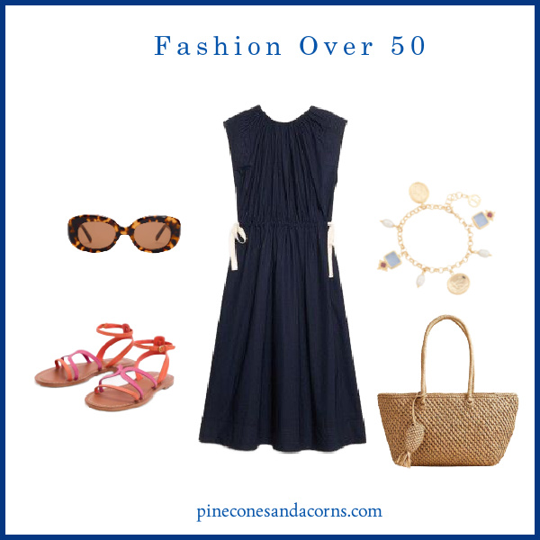 Fashion over 50 blue dress outfit with pink and orange sandals, whicker bag, gold and blue bracelet and tortoise sunglasses.