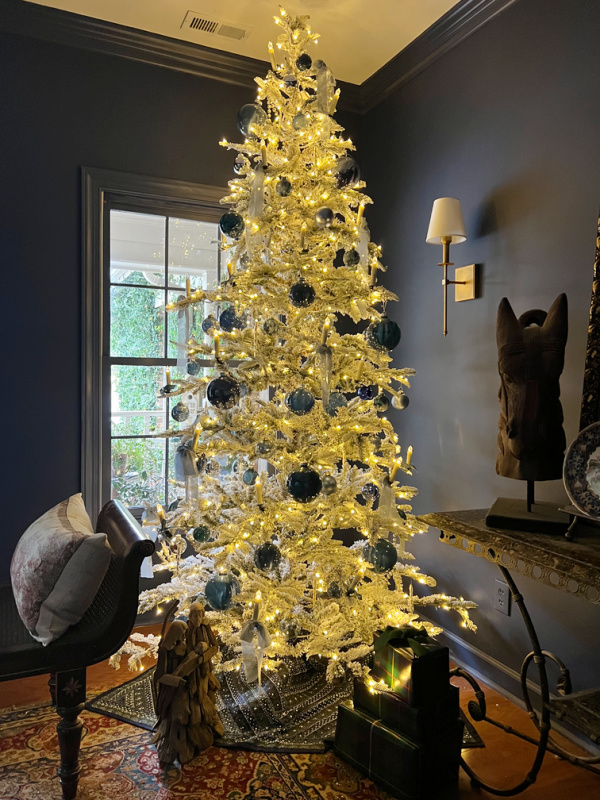 flocked white tree with blue ornaments.