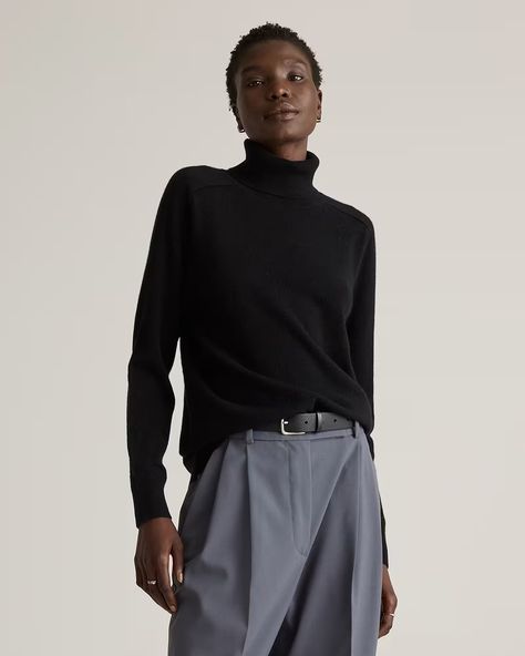 Woman wearing a black turtleneck sweater.