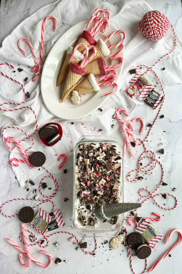 Peppermint Bark Cookies and Cream No Churn Ice Cream with a white platter of red and white dipped sugar cones.