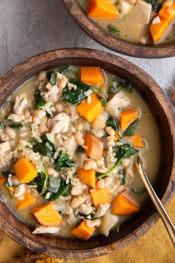 Creamy Chicken and Sweet Potato Soup with brown rice, white beans, baby spinach, and a rich broth.