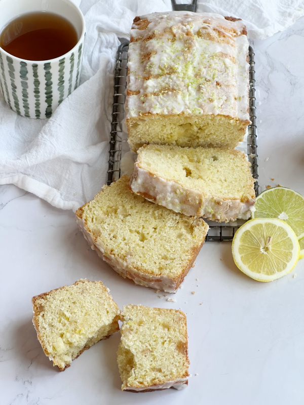 Triple Citrus Quick Bread sliced with a cup of tea.