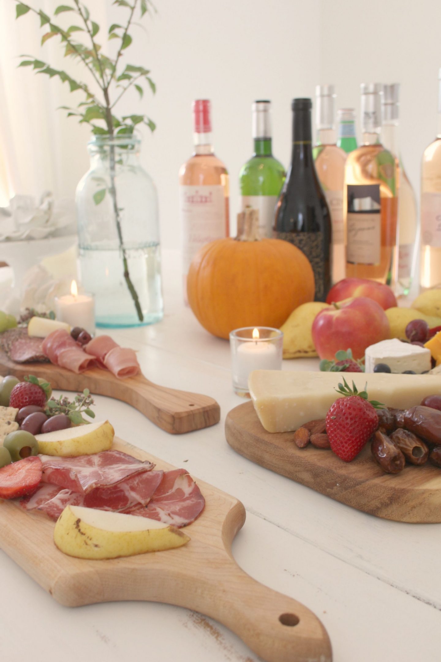 Beautiful cheese boards on white farmhouse table with wine