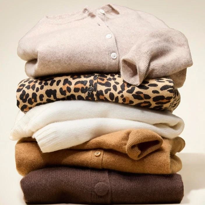 Folded cashmere sweaters in tan, camel, ivory, leopard, and cocoa brown, a classic wardrobe for women over 50