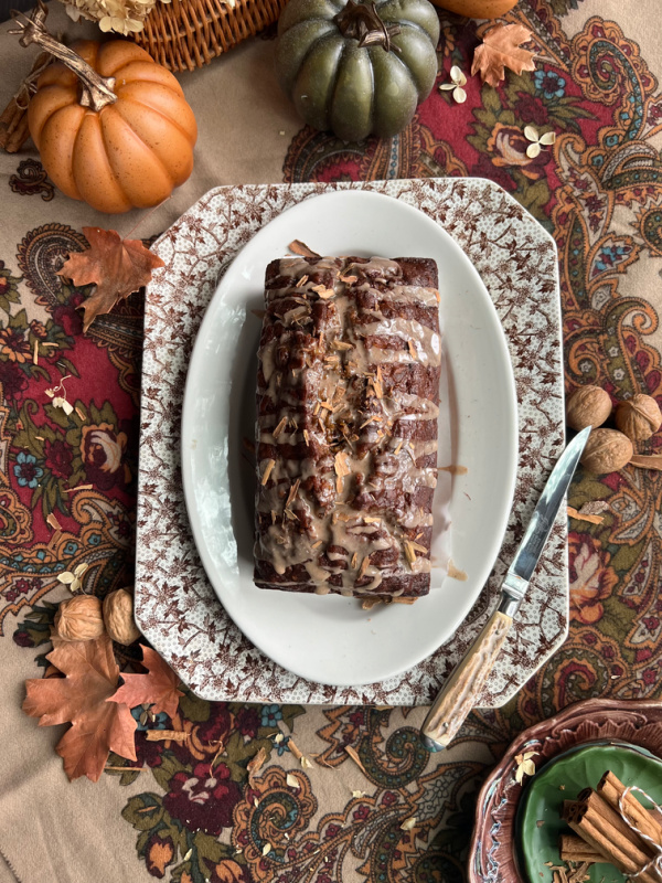 Fall quick bread flatlay with pumpkins, walnuts and cinnamon sticks.
