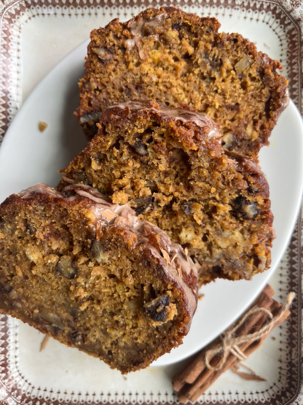 pumpkin bread, three slices on a white plate.